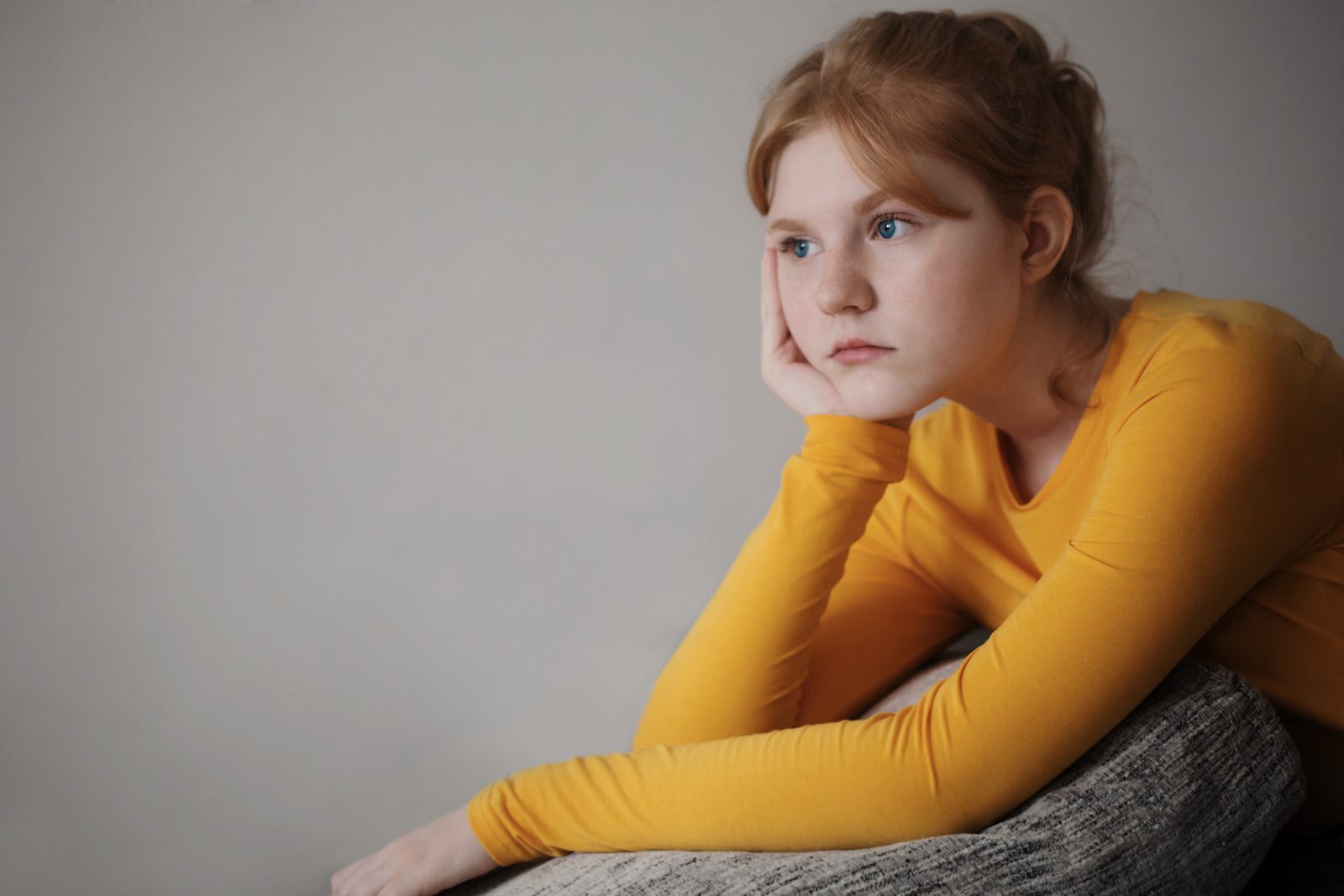 Teenager sitting thoughtfully, looking into the distance
